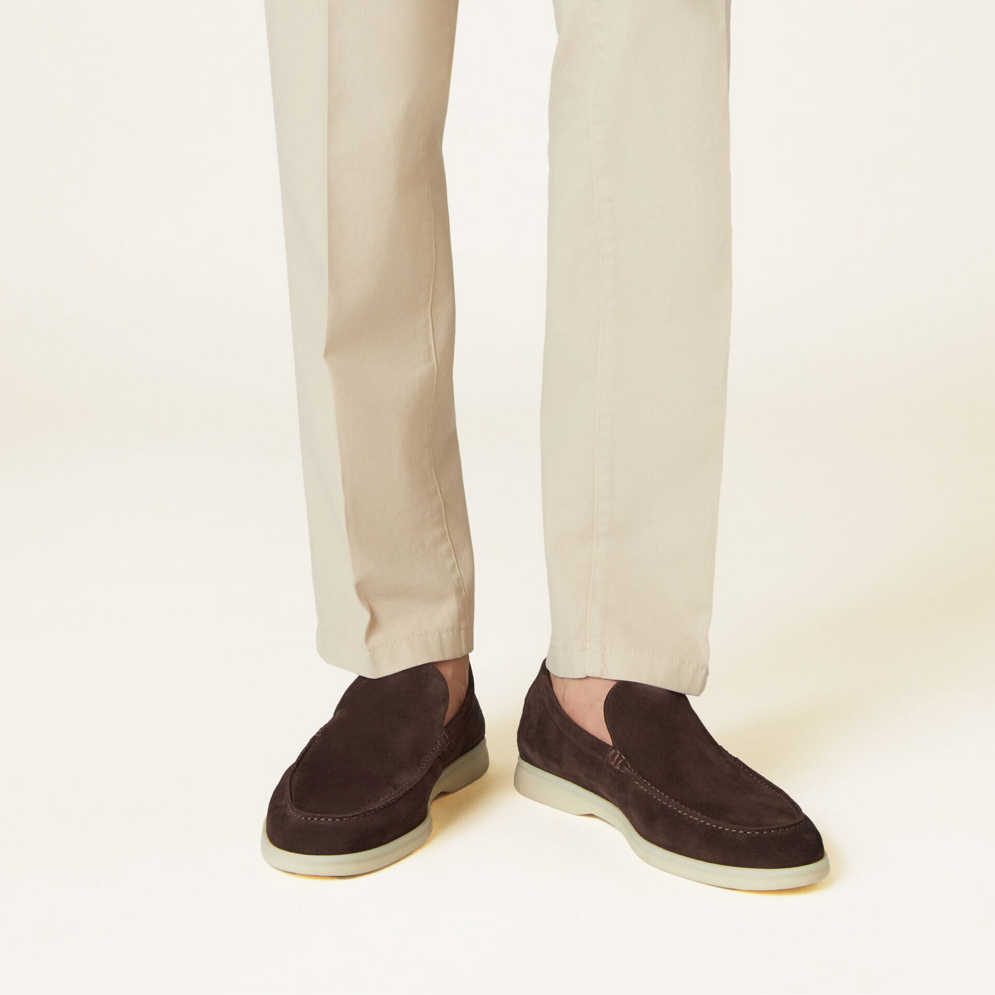 Brown leather loafers with gold bar detail on wooden bench