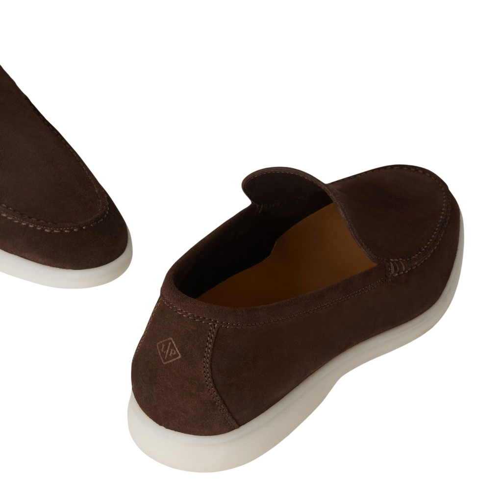 Brown slip-on shoes with a white sole on a white background