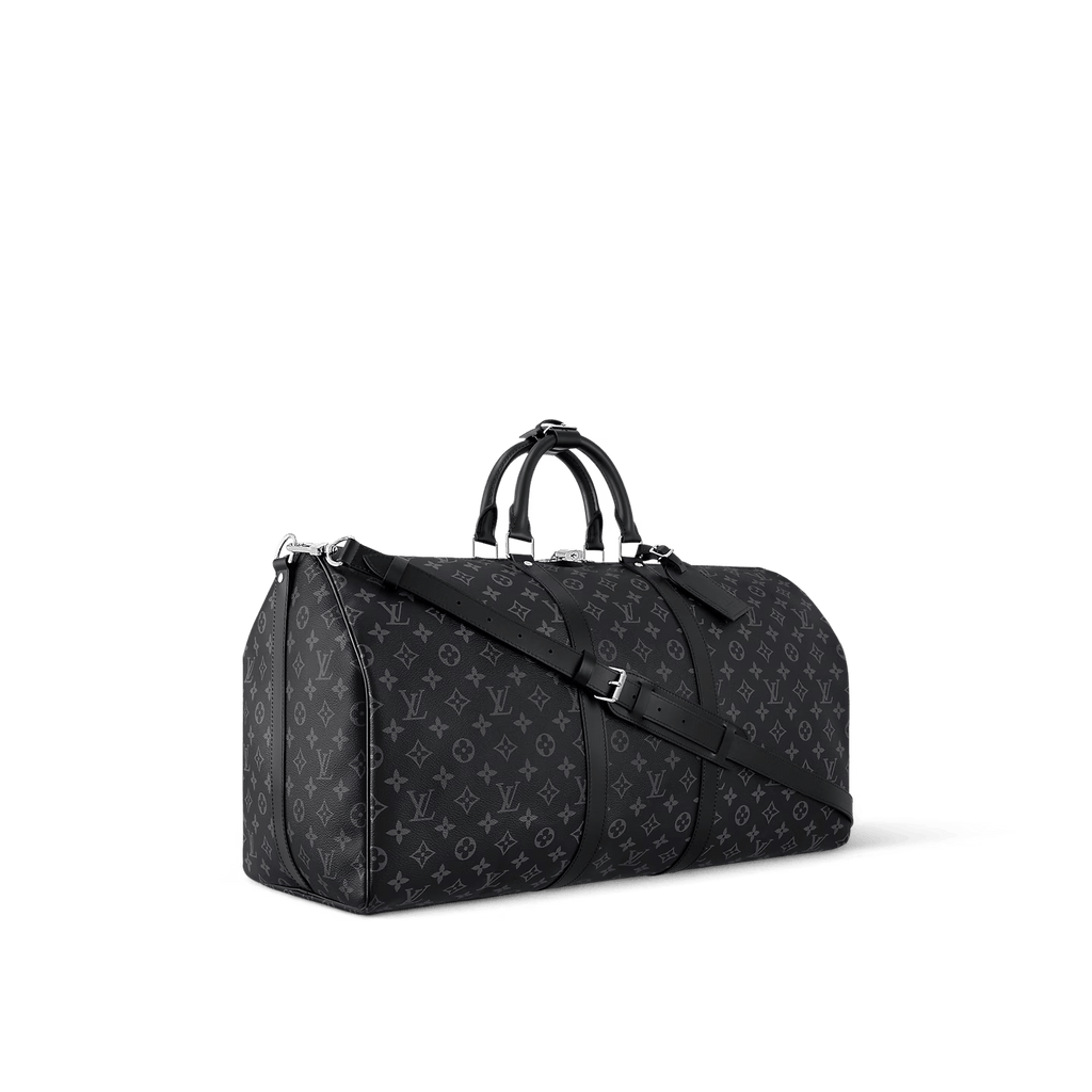 Black oversized weekender bag with leather handles and crossbody strap on luggage